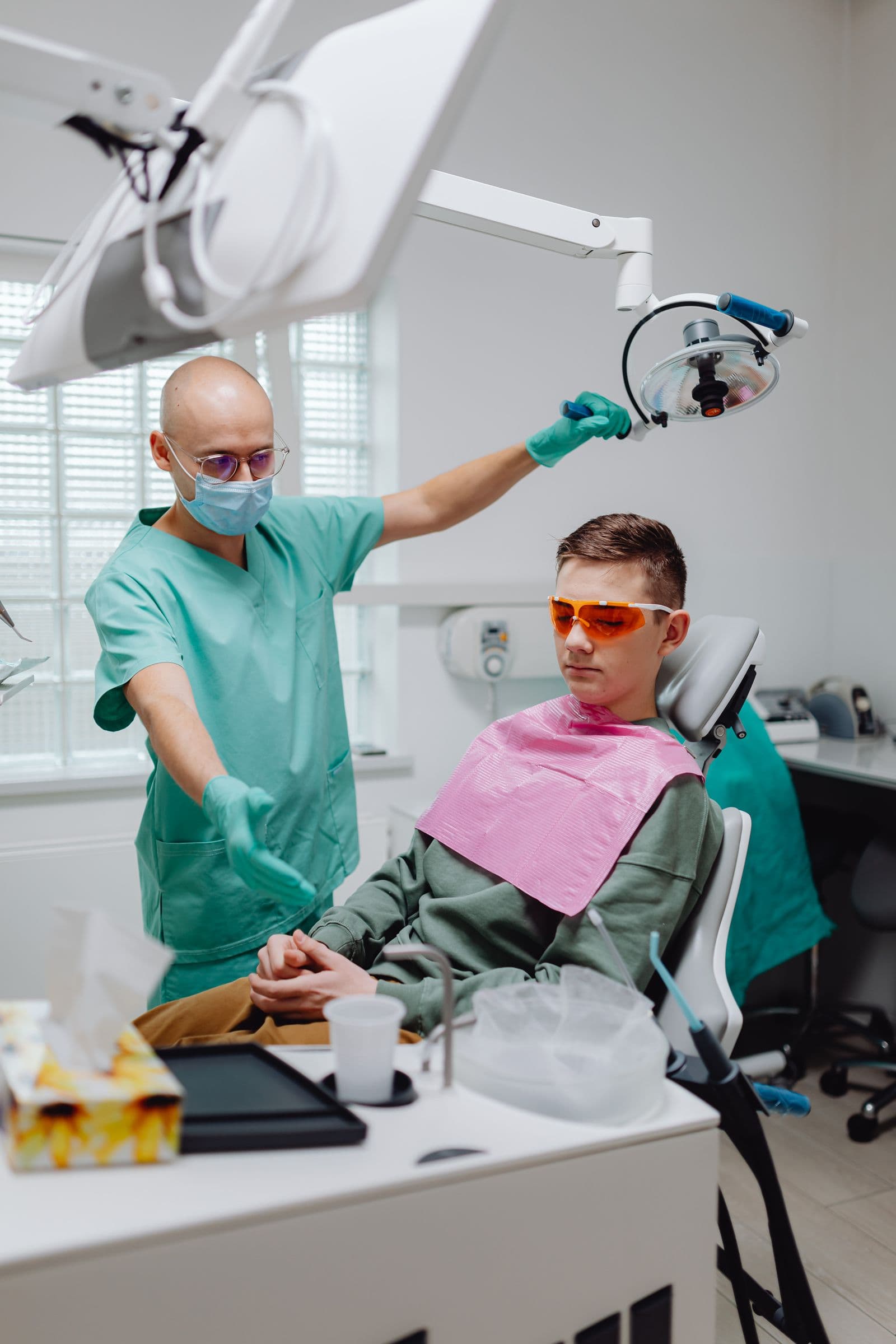 Een behandelaar van Oral Care Clinics aan het werk in de lichte behandelkamer